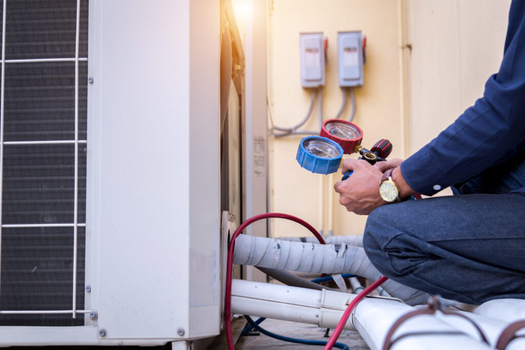Technician using gauges on HVAC system for furnace repair in Sacramento, ensuring efficient heating and air quality.