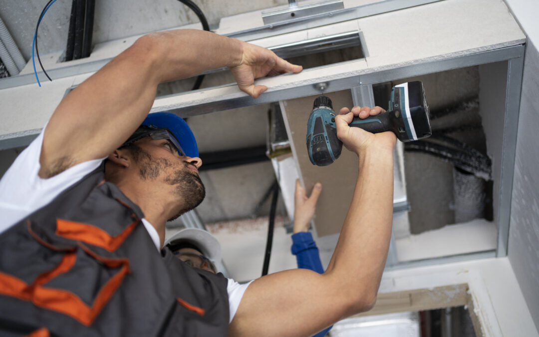 Technician installing air conditioning system components with power tools in Elk Grove home.
