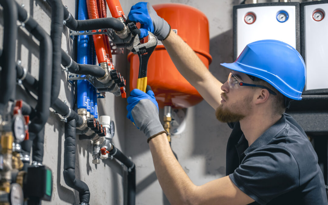 Technician using a wrench to adjust pipes and valves in a high-efficiency furnace installation, showcasing HVAC service and maintenance.
